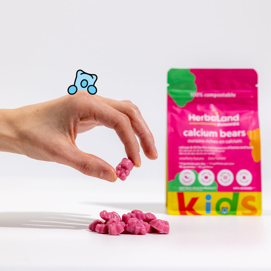 Person holding herbaland gummy bears, with calcium bears pouch to maintain healthy bones and teeth for kids with strawberry banana flavour in the background